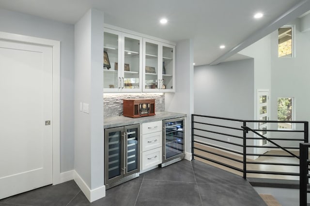 bar with white cabinets and beverage cooler