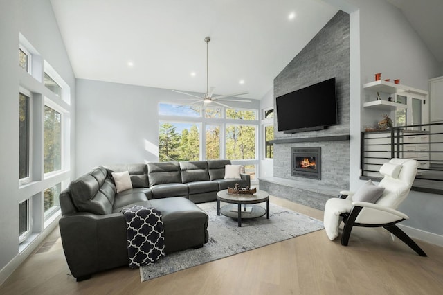 living room with a fireplace, high vaulted ceiling, light hardwood / wood-style flooring, and ceiling fan