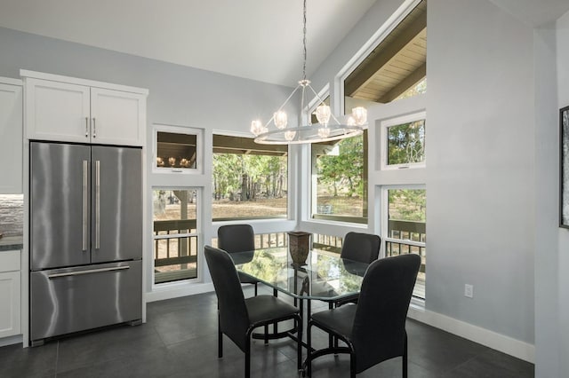 dining area with high vaulted ceiling and a chandelier