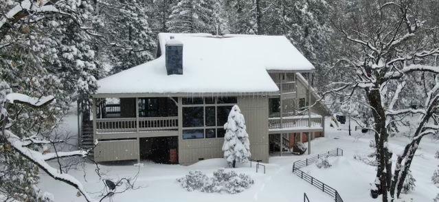 view of snow covered back of property