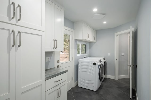 laundry room featuring dark tile patterned flooring, washer and dryer, and cabinets