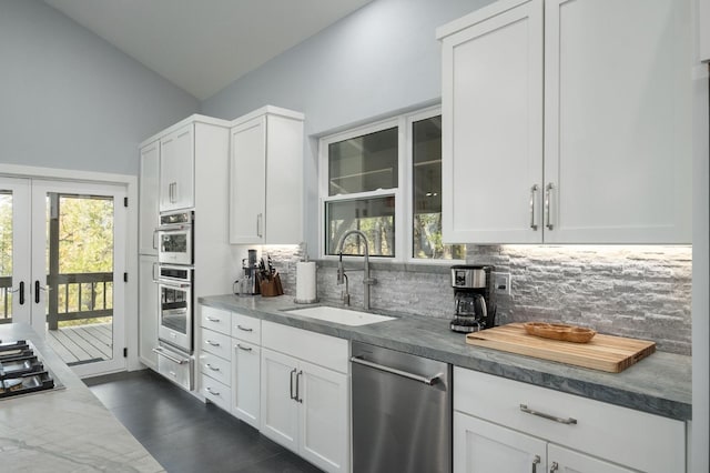 kitchen with backsplash, white cabinetry, and dishwasher