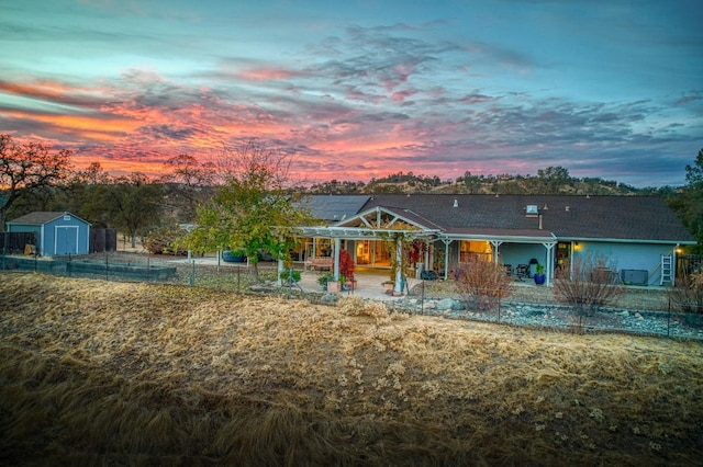 view of front facade with solar panels, a patio, and a shed