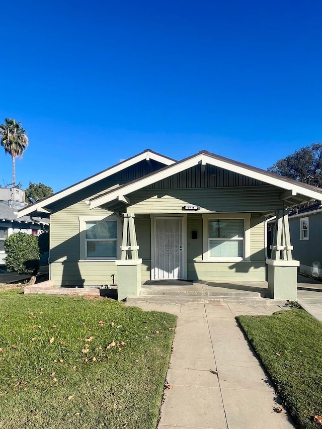 view of front of house with a porch and a front lawn