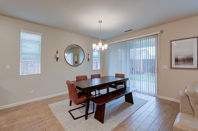 dining room featuring light wood-type flooring and an inviting chandelier