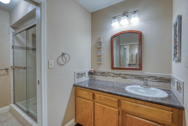 bathroom featuring tile patterned flooring, vanity, and a shower with shower door