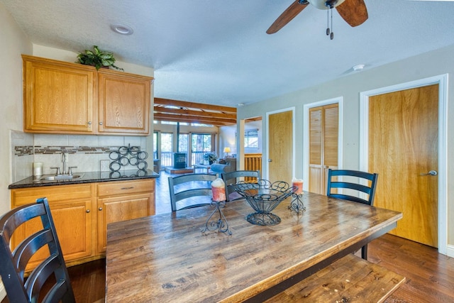 dining room with a textured ceiling, ceiling fan, dark hardwood / wood-style flooring, and sink