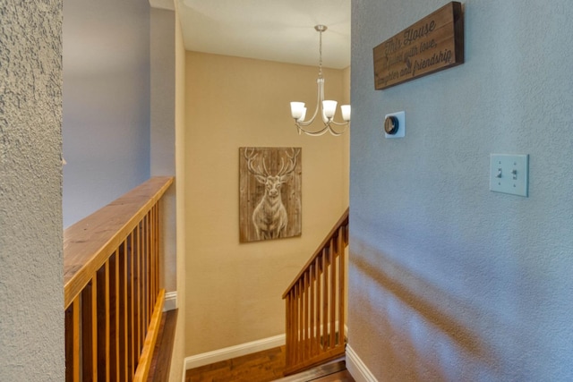 stairs featuring a notable chandelier