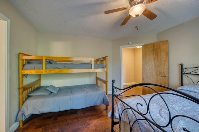 bedroom with a textured ceiling, dark hardwood / wood-style flooring, and ceiling fan