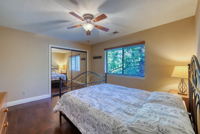 bedroom with ceiling fan, a closet, dark wood-type flooring, and a textured ceiling