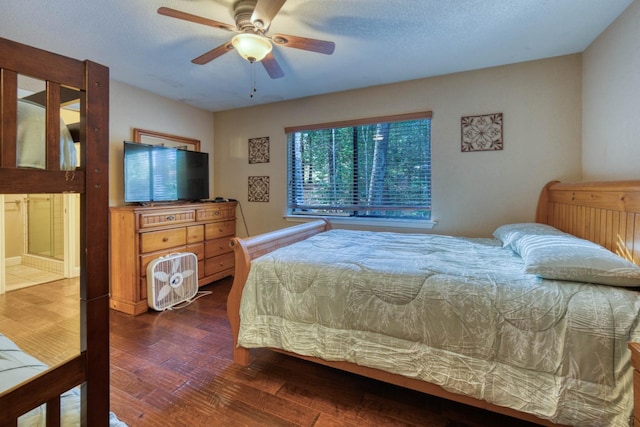 bedroom featuring dark hardwood / wood-style floors, ceiling fan, and a textured ceiling