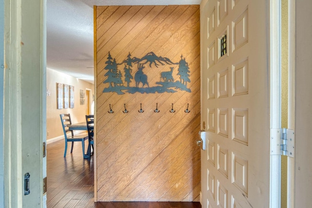 corridor with hardwood / wood-style floors and wood walls