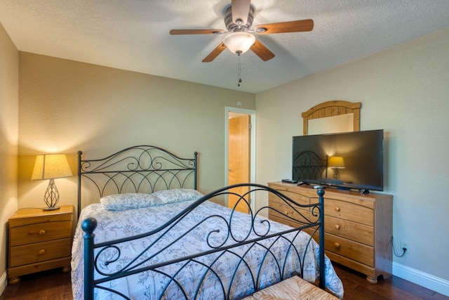 bedroom with ceiling fan, dark wood-type flooring, and a textured ceiling