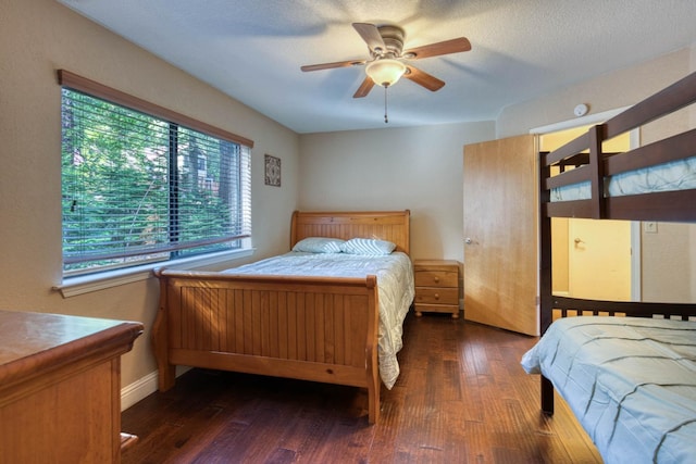 bedroom featuring a textured ceiling, ceiling fan, and dark wood-type flooring