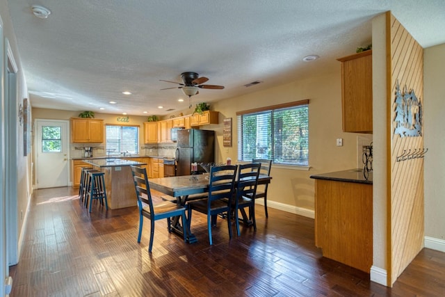 dining room with plenty of natural light, ceiling fan, and dark wood-type flooring