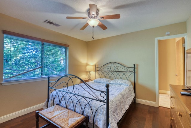 bedroom featuring ceiling fan, dark hardwood / wood-style floors, and a textured ceiling