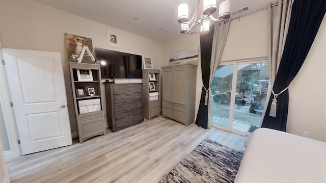 bedroom featuring access to exterior, light hardwood / wood-style flooring, and a chandelier