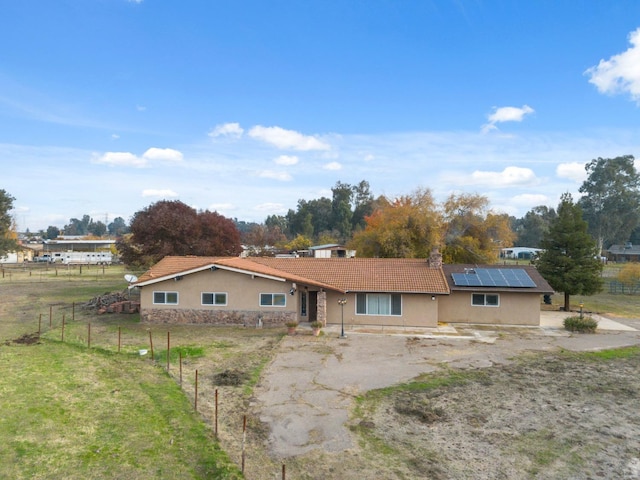 12713 Rd 37 Unit 1/2, Madera, CA 93636 - rear view of house featuring stucco siding, solar panels, a tiled roof, and stone siding