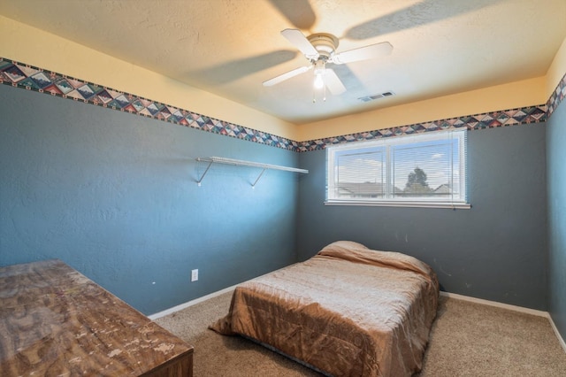 carpeted bedroom featuring a textured ceiling and ceiling fan