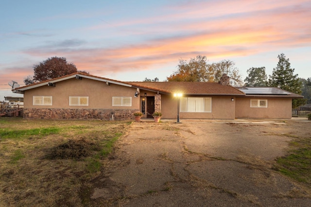 12713 Rd 37 Unit 1/2, Madera, CA 93636 - ranch-style home featuring a chimney, solar panels, a tile roof, and stucco siding