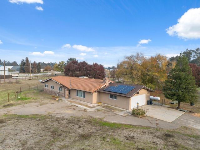 12713 Rd 37 Unit 1/2, Madera, CA 93636 - single story home with stucco siding, a tiled roof, driveway, solar panels, and fence