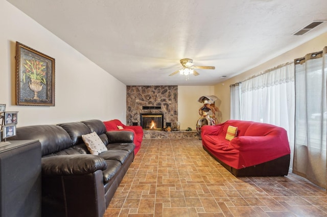 living room featuring a fireplace and ceiling fan