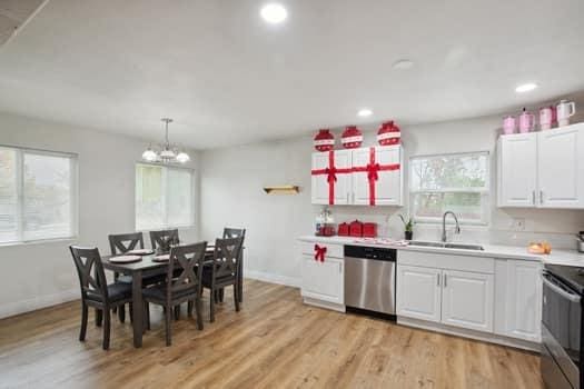 kitchen with appliances with stainless steel finishes, decorative light fixtures, white cabinetry, sink, and plenty of natural light