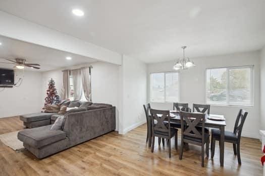 dining space featuring ceiling fan with notable chandelier and light hardwood / wood-style flooring