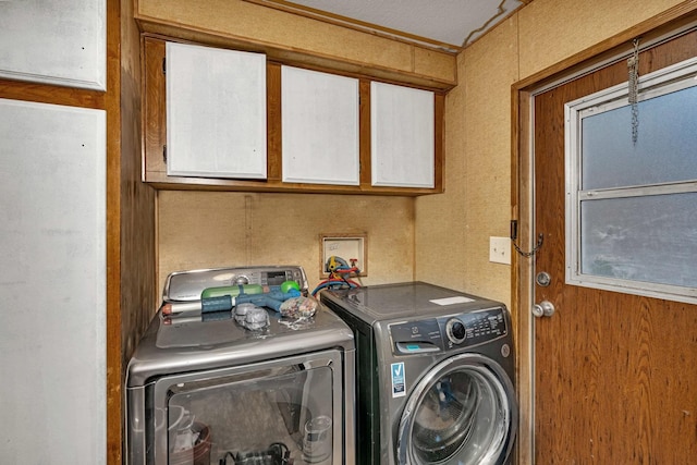 laundry area featuring washer and clothes dryer and cabinets