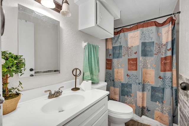 bathroom featuring a textured ceiling, vanity, toilet, and a shower with curtain