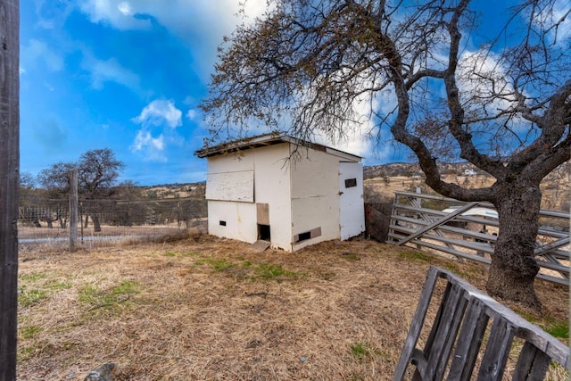 view of property exterior with a rural view and a storage shed