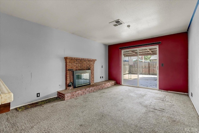 unfurnished living room featuring carpet flooring, a fireplace, and a textured ceiling