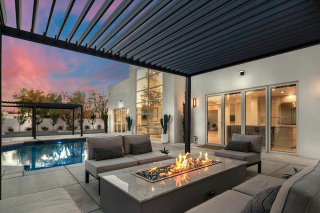 patio terrace at dusk featuring a pergola and an outdoor living space with a fire pit