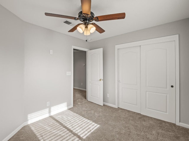 unfurnished bedroom featuring light colored carpet, a closet, and ceiling fan