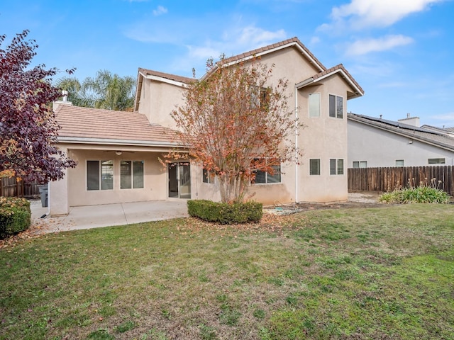 rear view of house featuring a yard and a patio area