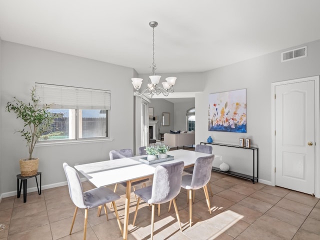 dining space with light tile patterned floors and a chandelier