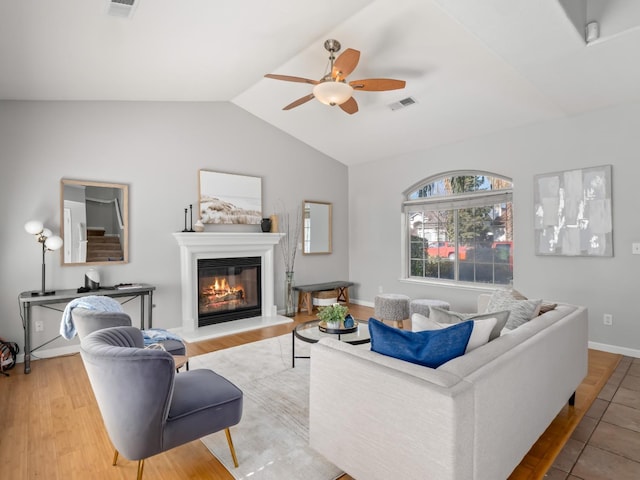 living room featuring ceiling fan, lofted ceiling, and light hardwood / wood-style floors