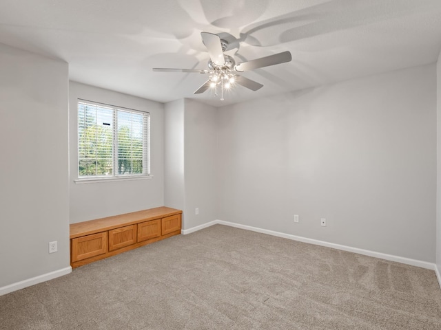 carpeted spare room with ceiling fan