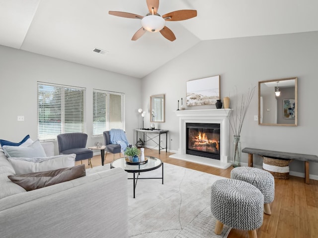 living room featuring vaulted ceiling, ceiling fan, and light wood-type flooring