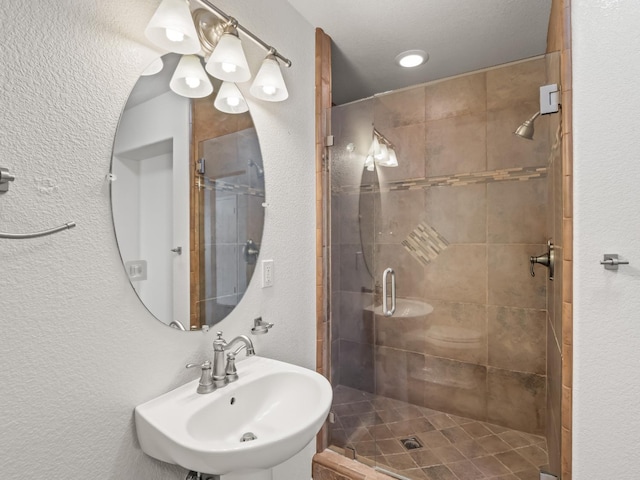 bathroom featuring an enclosed shower and sink