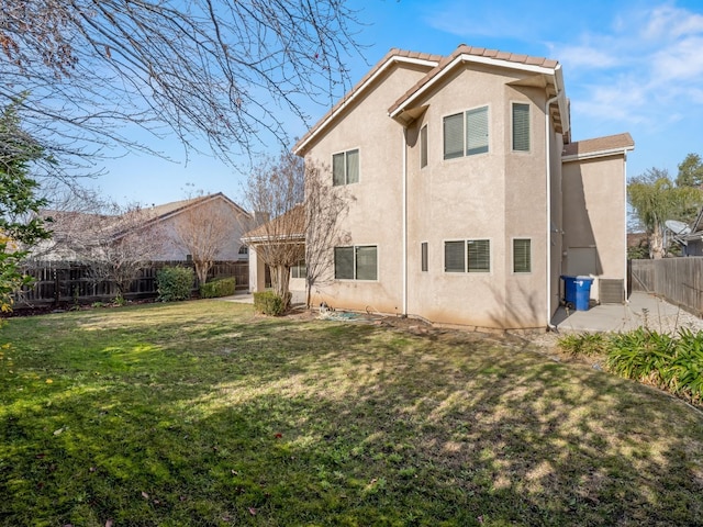 rear view of house featuring a patio area and a lawn