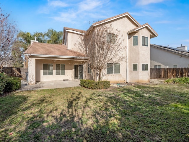 back of house with a lawn and a patio area