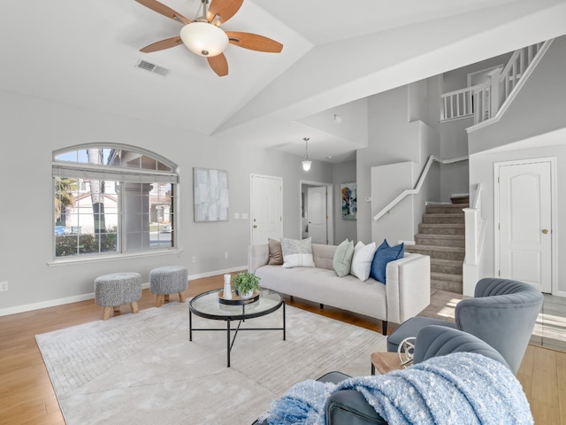 living room featuring light hardwood / wood-style flooring, high vaulted ceiling, and ceiling fan