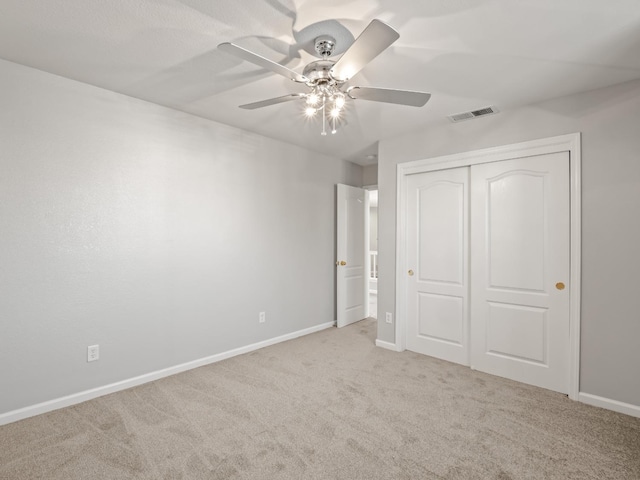 unfurnished bedroom featuring light carpet, a closet, and ceiling fan