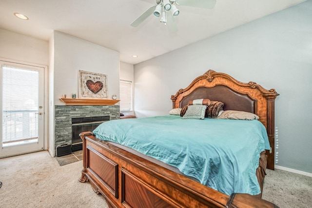 carpeted bedroom featuring ceiling fan and a fireplace