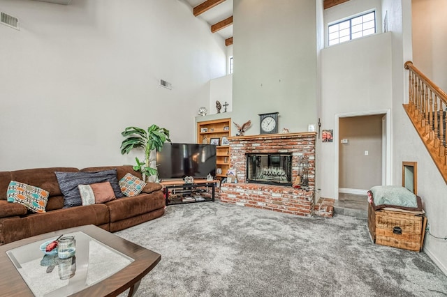 carpeted living room featuring beamed ceiling, a high ceiling, and a fireplace