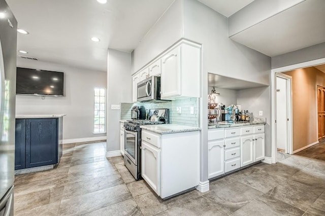 kitchen featuring backsplash, light stone counters, white cabinetry, and stainless steel appliances