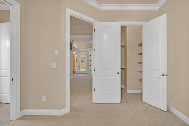 unfurnished bedroom with french doors, light colored carpet, and crown molding