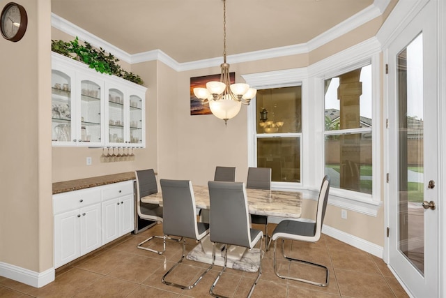 tiled dining room with a notable chandelier and crown molding