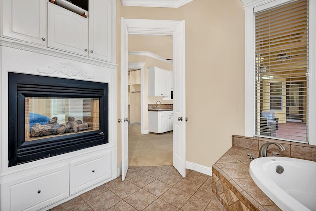 bathroom with tile patterned floors, vanity, crown molding, a multi sided fireplace, and tiled bath